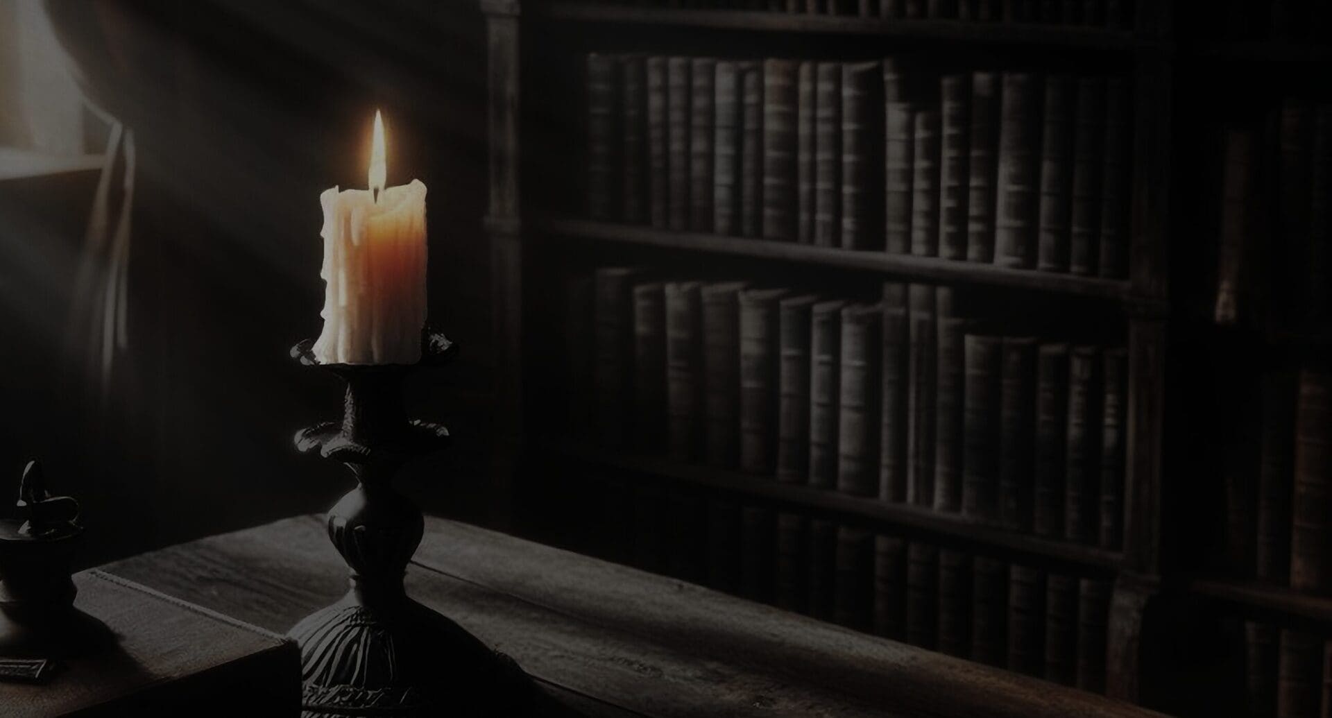 A candle in front of some books on the shelf